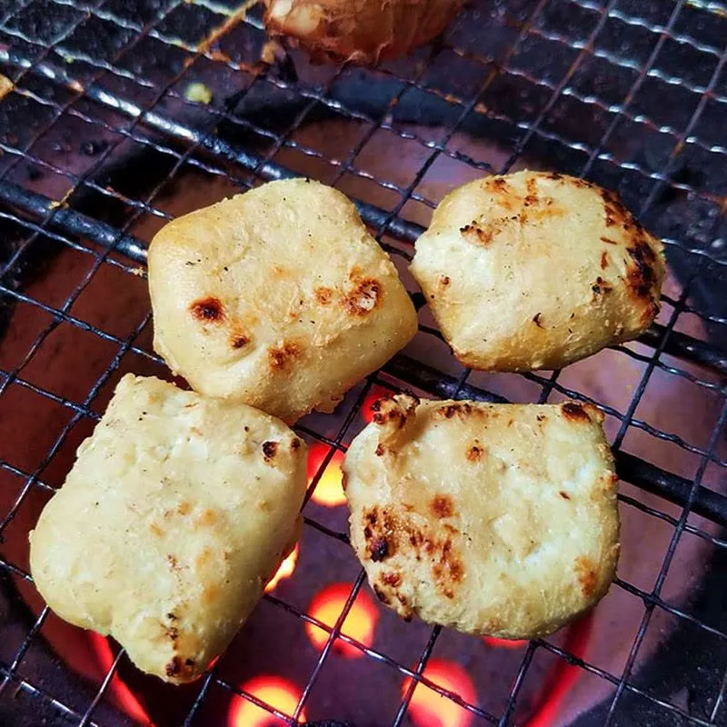 正在烤肉架上炙烤的建水毛豆腐,香氣撲鼻,口感豐富